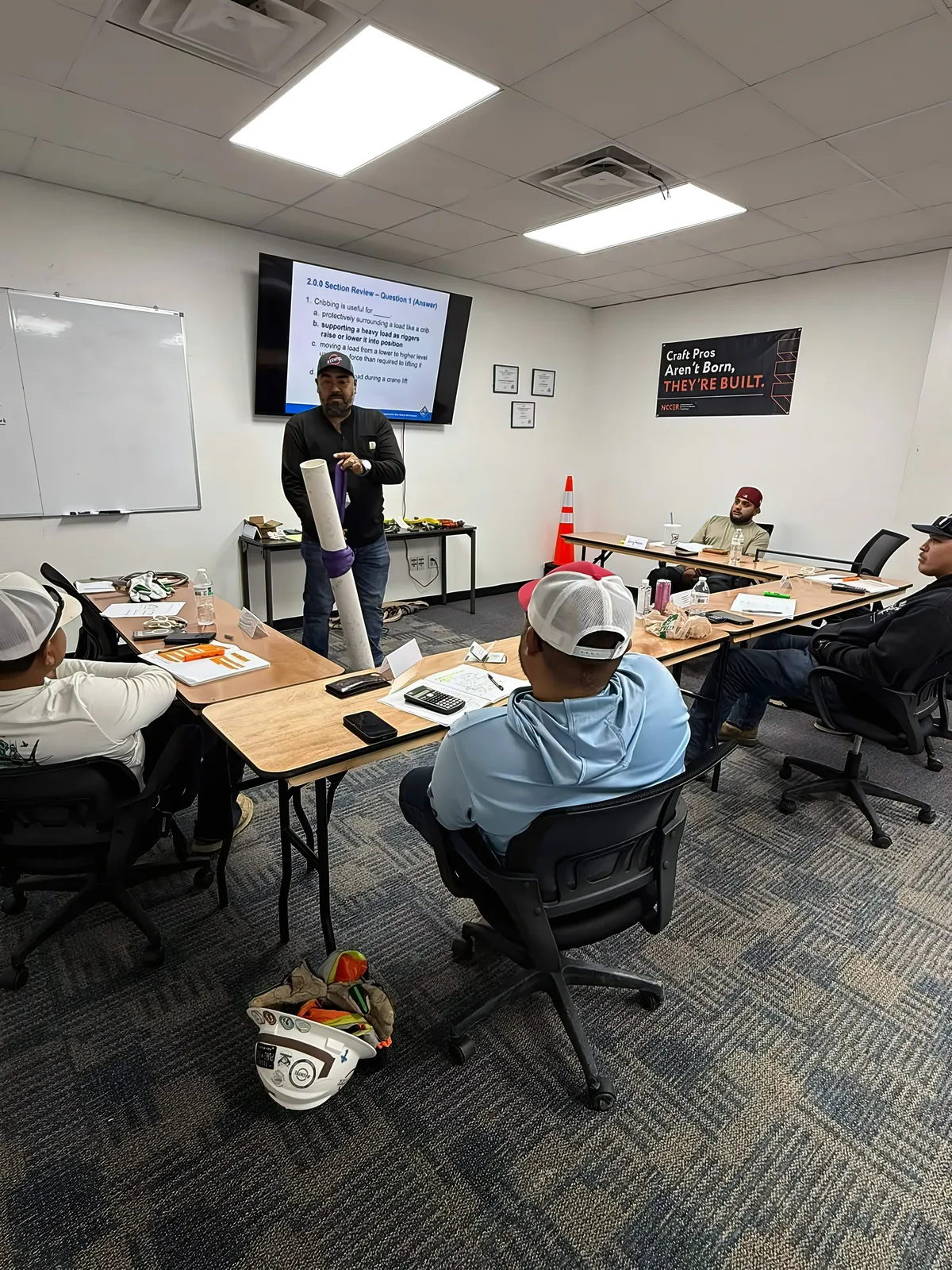 Instructor demonstrating a sling hitch on a load during class