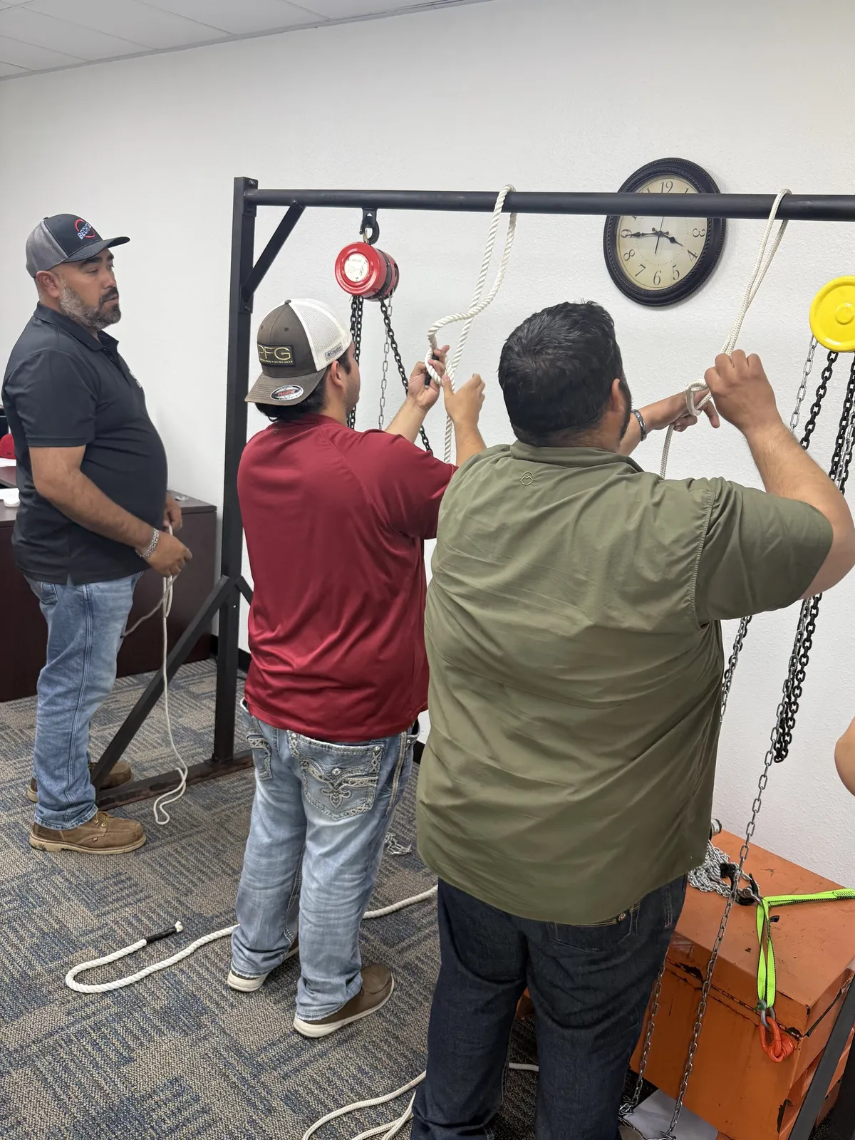 Students tying the two most important knots in rigging on the training gantry