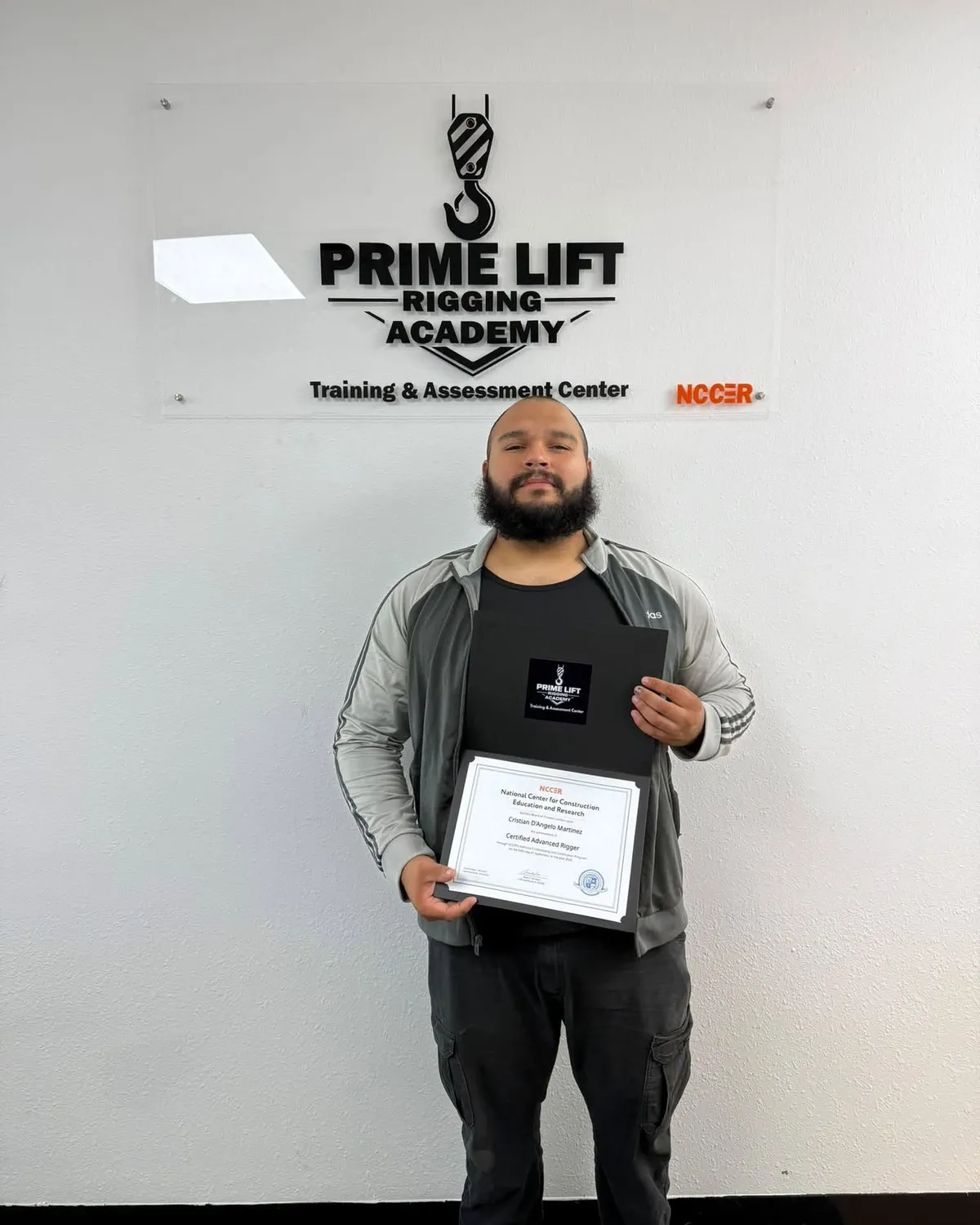 Cristian M., a Prime Lift graduate, holding his NCCER Certified Advanced Rigger certificate