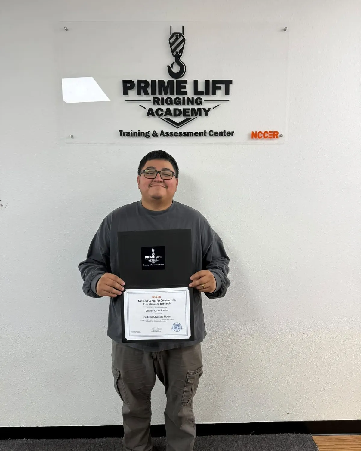 Santiago T., a Prime Lift graduate, holding his NCCER Certified Advanced Rigger certificate